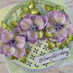 a close up of a card with purple flowers on it and the words happy birthday