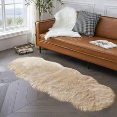 a living room with a couch, chair and rug on the floor in front of a window