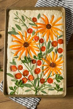 an art work with orange flowers and green leaves on a baking sheet in a pan