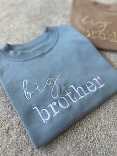 The perfect touch to reveal your new arrival to a sibling 🫶🏼 Perfect to get the older siblings excited about their new arrival!  When I was pregnant with my second son, my son loved wearing his big brother tshirt proudly and was so excited when he read it himself to find out about his new baby sibling 🤍 Can also be made to say 'big sister' aswell as 'little brother' or 'little sister' for the baby to match 🤍 (Please see other listings in my shop as I can't have them all under one item!) 100% Upgraded To Big Brother, Big Brother Embroidered Shirt, Blue T-shirt For Gender Reveal On Father's Day, Blue T-shirt For Father's Day Gender Reveal, Personalized Crew Neck T-shirt For Gender Reveal, Older Sibling Pregnancy Announcement, Baby Brother Announcement, Big Brother Shirt Announcement, Little Brother Announcement