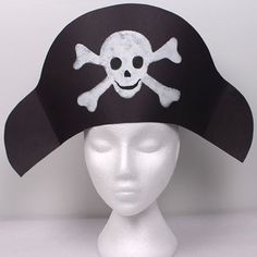 a white mannequin head wearing a pirate hat with skull and crossbones