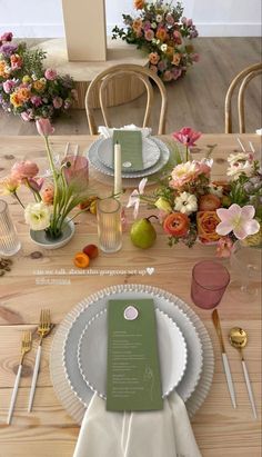 the table is set with flowers and place settings