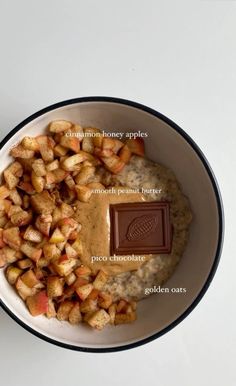 a bowl filled with oatmeal and apples next to a bar of chocolate