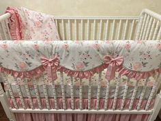 a white crib with pink flowers and bows