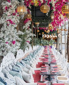 tables and chairs are lined up in front of hanging lights with flowers on the ceiling