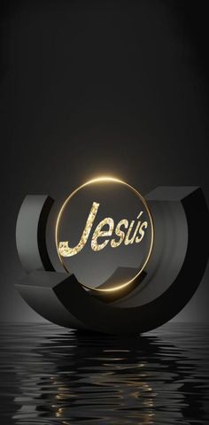 the word jesus is illuminated in gold on a black surface with water and dark background