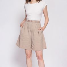 Vintage 80s/90s khaki cotton pleated shorts, with a high waist and a wide leg. Shown clipped on the model in the first two photos. Measurements and Condition: Fits like: Labeled size 12, see measurements below to ensure fit for modern sizing Fabric: Cotton Brand: Cenza, made in USA Condition: Good, with some faint 1/4" or smaller yellow spots on the front of the right leg and a couple on the lower front of the left leg, one on the back left seat, and three tiny white paint spots on the back left Short Pleated Cotton Bottoms, Khaki Relaxed Fit Wide Leg Shorts, Khaki Wide Leg Relaxed Fit Shorts, Khaki Wide Leg Shorts With Relaxed Fit, Cotton Pleated Short Bottoms, Vintage Beige Shorts For Spring, Beige Pleated Shorts, High-waisted Pleated Cotton Shorts, Khaki Wide-leg Shorts For Spring