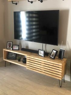 a flat screen tv mounted to the side of a wooden entertainment center in a living room