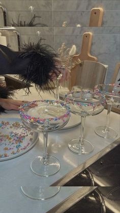 a woman is decorating glasses with sprinkles