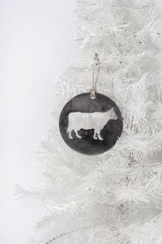 a black and white ornament hanging from a christmas tree in the shape of a sheep