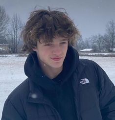 a young man is standing in the snow