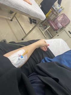 a person laying in a hospital bed with an iv tube attached to their arm and hand