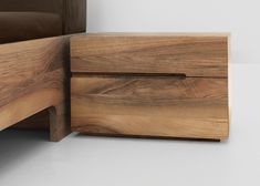 a close up of a bed with a wooden headboard and night stand next to it