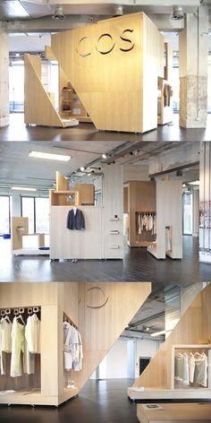 the inside of a clothing store with wooden shelves and clothes hanging on hangers in it