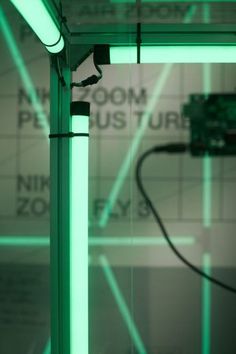 an electronic device is being displayed in a room with green lights on the wall and below it