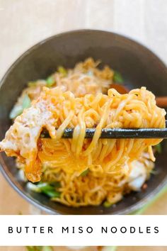 a bowl filled with noodles and sauce on top of a wooden table