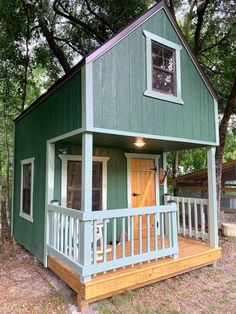 a small green house sitting in the woods