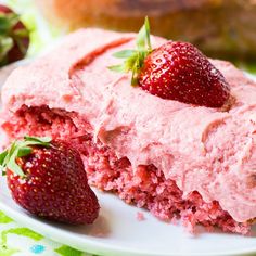 a close up of a piece of cake on a plate with strawberries next to it