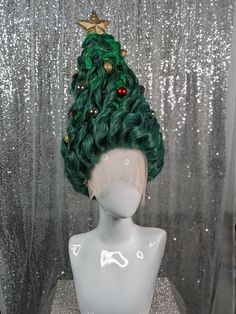 a white mannequin head with a green christmas tree on it's head