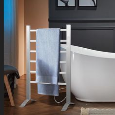 a white bath tub sitting next to a wooden floor