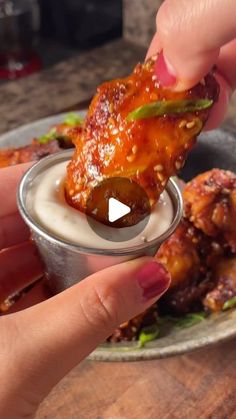 a person dipping some food into a small bowl