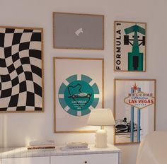 a white dresser sitting next to a wall filled with pictures and posters on it's side