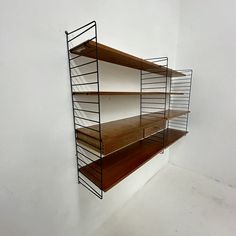 a shelf with three wooden shelves on each side and two metal bars at the top