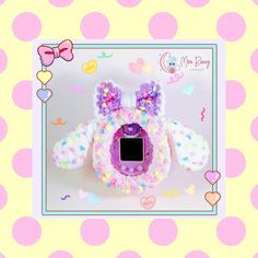 a pink camera with bows and hearts on the front, sitting in a polka dot frame