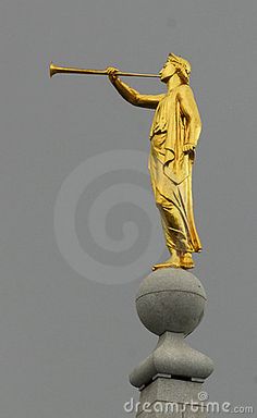 a golden statue on top of a building with a hammer in it's hand