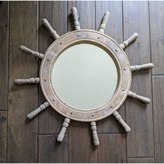 a mirror that is on top of a wooden floor in the shape of a ship's wheel