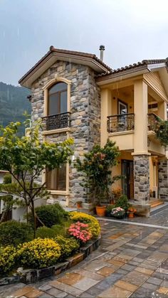 a large house with lots of flowers in the front yard