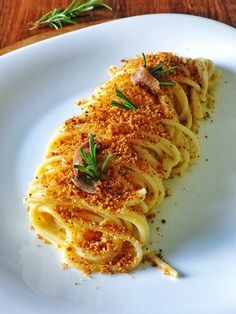 a white plate topped with pasta covered in sauce and garnished with sprinkles