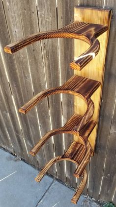 a wooden shelf sitting on the side of a fence