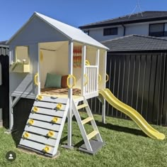 there is a play house with a slide in the yard