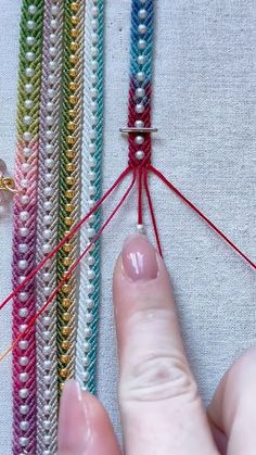 someone is stitching together several different colors of thread