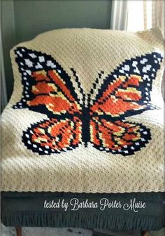 a crocheted butterfly pillow sitting on top of a chair