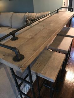 a living room filled with furniture and a wooden table topped with stools next to a couch