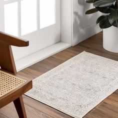 a wooden chair sitting next to a white rug on top of a hard wood floor