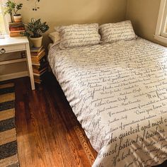 a bed sitting in a bedroom next to a window with a plant on top of it