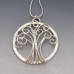 Sterling silver 'Tree of Life' pendant, 1 1/2" diameter, outer ring features hammered detailing and hangs from a sterling snake chain. The Tree of Life represents the interconnectedness of everything in the universe. It symbolizes togetherness and serves as a reminder that you are never alone or isolated, but rather that you are connected to the world.Created from responsibly sourced silver. Each piece is handmade, because of this there may be slight variations in your finished piece from the ph Gemstone Stacking Ring, Celtic Heritage, Never Alone, Irish Celtic, Silver Spinner Rings, The Tree Of Life, Link Earrings, Silver Tree, Tree Of Life Pendant