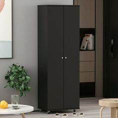 a black cabinet sitting in the corner of a room next to a table and chair