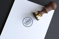 a wooden stamper sitting on top of a piece of paper with the word logo printed on it