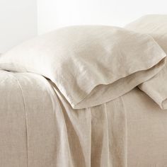 an unmade bed with sheets and pillows