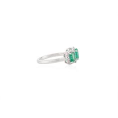 an emerald and diamond ring on a white background