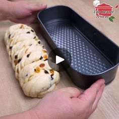 a person holding a pan filled with food on top of a wooden table next to a pastry