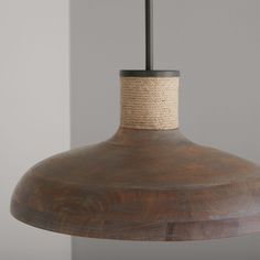 a wooden light fixture with rope hanging from it's end and an iron rod