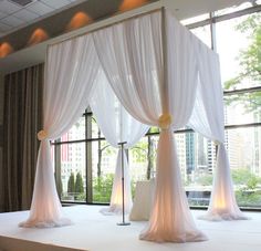 a bed with white drapes and lights on it