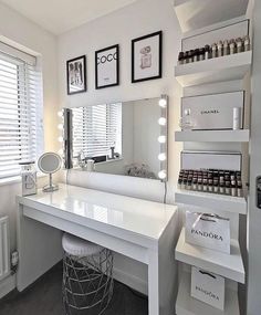 a white vanity with lots of lights on top of it and a mirror in the corner