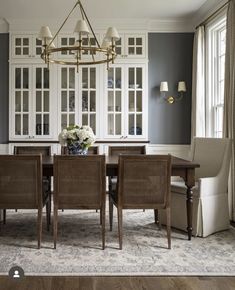 a dining room table with chairs and a chandelier hanging from the ceiling above it