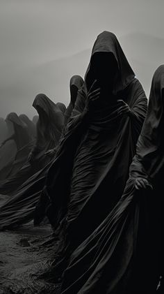 black and white photograph of hooded figures in the fog